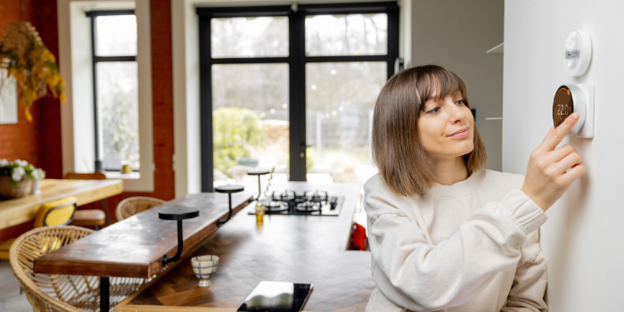 woman adjusting thermostat