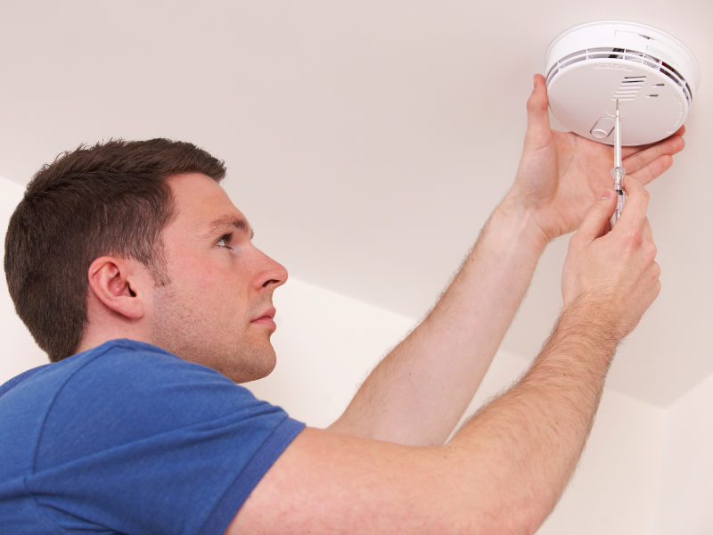 Homeowner changing smoke detector