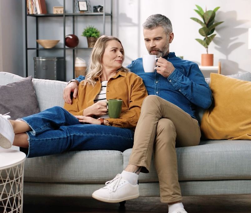 Screenshot 2025-10-27 at 8.43.54 AM Couple sitting on a couch drinking coffee
